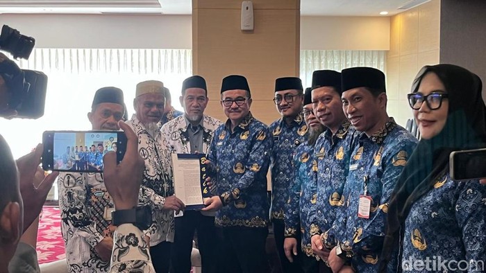 1763359441404-sekda-sulsel-dr-jufri-rahman-menyerahkan-sk-pengaktifan-kembali-menjadi-asn-kepada-dua-guru-sma-di-luwu-utara-1763344493029_169